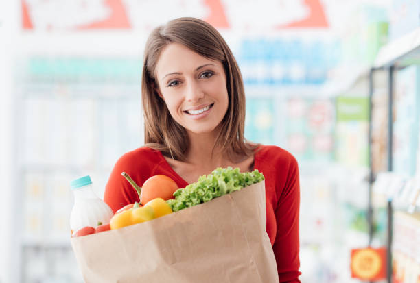 istock Woman holding a grocery bag 870754490