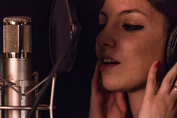 istock Young girl singing in a studio 870755554