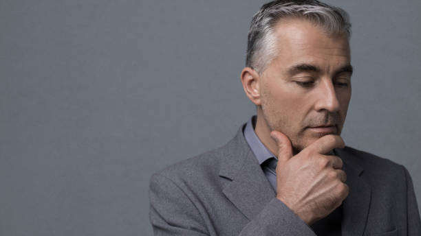 istock Pensive businessman with hand on chin 870758842
