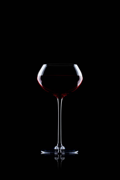 istock Glass of red wine on black with reflection 870761598