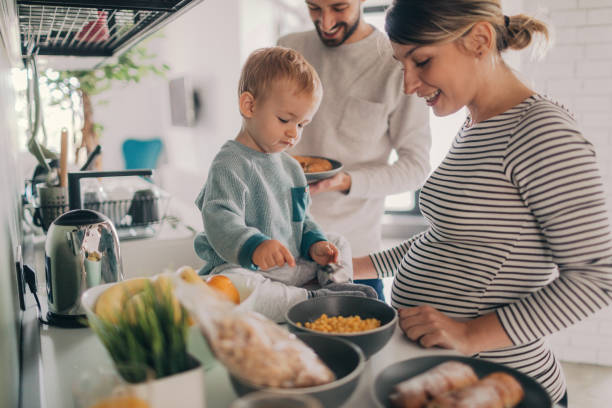 preparare la colazione insieme - domestic life family heterosexual couple young family foto e immagini stock