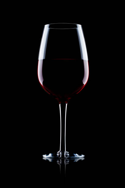 istock Glass of red wine on black with reflection 870761984