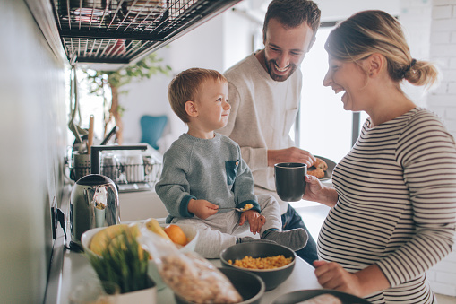 Photo of a young family preparing breakfast together in their kitchen