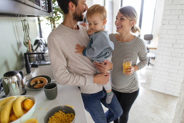 mattina frenetica nella nostra cucina - domestic life family heterosexual couple young family foto e immagini stock