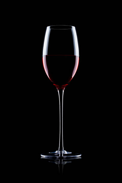 istock Glass of red wine on black with reflection 870765264