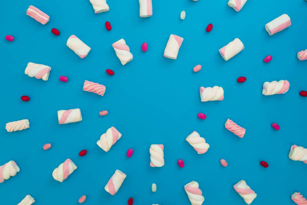 istock Colored candy and marshmallow on blue background. Flat lay, top view 870765444