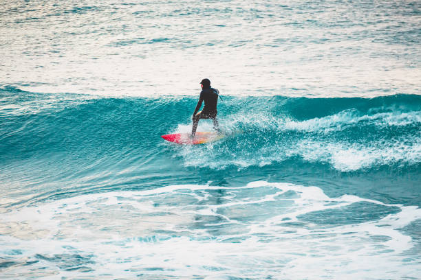 istock Winter surfing in ocean. Surfer on blue wave 870770126