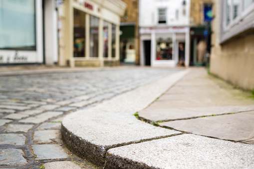 Low down photo of a kerbside on a cobbled street.