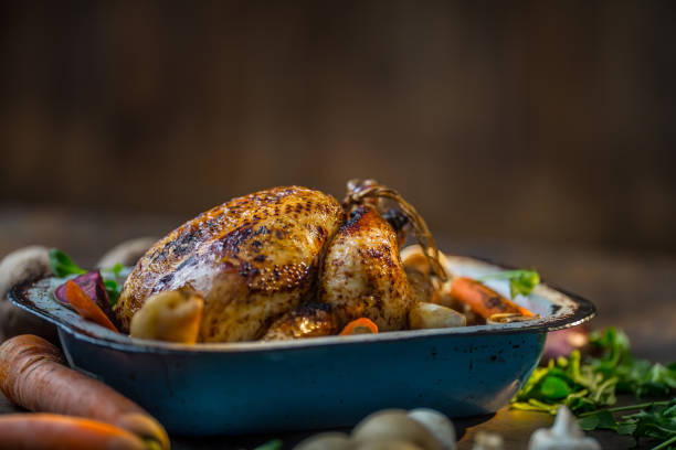 istock Roast whole turkey or  chicken in old pan with vegetables 870781254