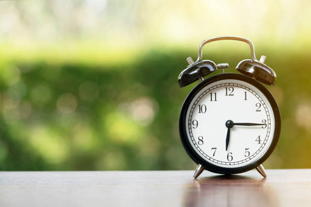 istock Retro alarm clock on wooden table, vintage style 870782252