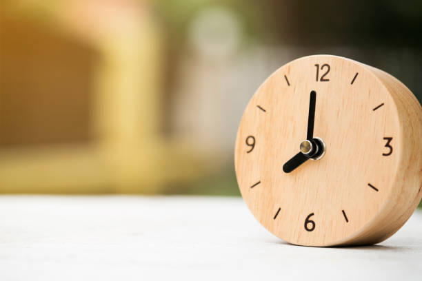 Retro alarm clock on wooden table, vintage style