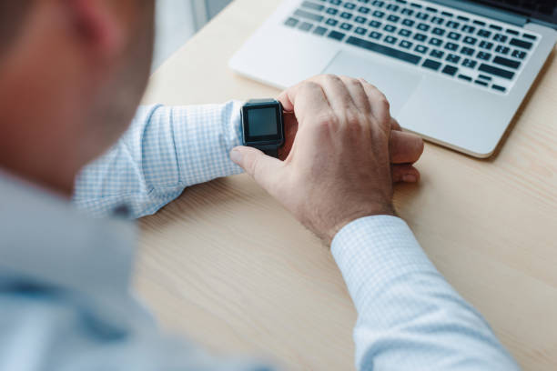 istock businessman checking time on smart watch 870782340