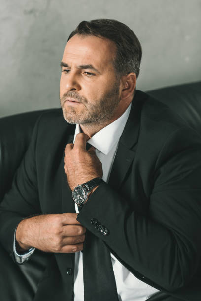 istock businessman in suit tying necktie 870788218