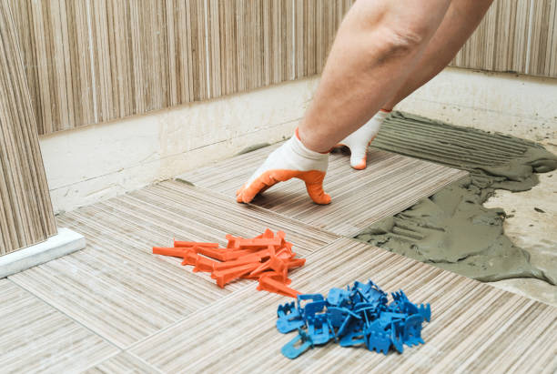 Installation of ceramic tiles. Installation of ceramic tiles. A tile's hand is puting a tile on an adhesive. building storey stock pictures, royalty-free photos & images