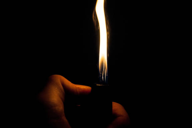 istock Close up view of real sparking light from lighter in dark black background 870796098