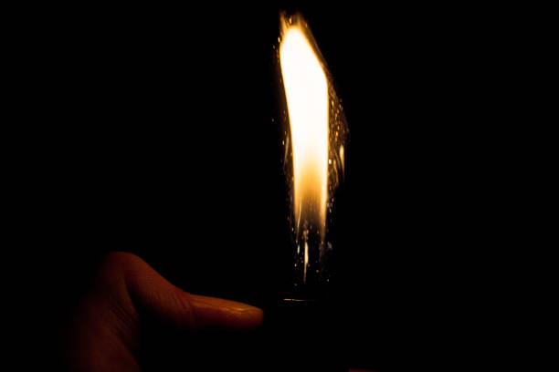 istock Close up view of real sparking light from lighter in dark black background 870796124