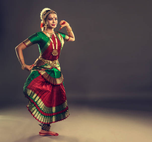 Beauty of classical indian dance. Young woman dancer  is performing indian dance bharatanatyam. Young attractive woman dancer of classical indian dance bharatanatyam, dressed in special dance suit and jewelry set, is demonstraiting simbolic poses of anciant folk dance. bharatanatyam dancing stock pictures, royalty-free photos & images