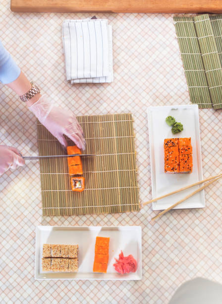 istock Top view of professional chef making and serving California sushi rolls in kitchen 870802570