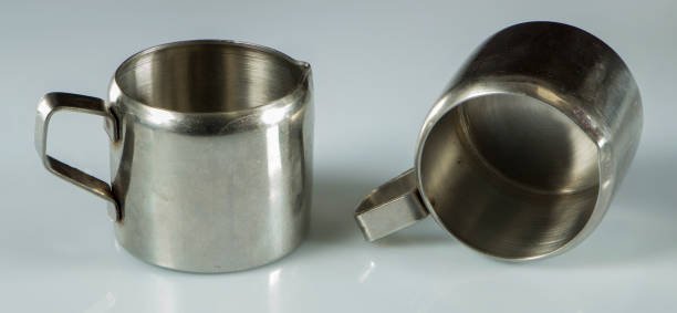 istock two metal nickel-plated cups on a white background. 870811124