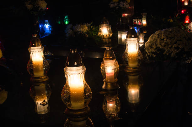 istock Flaming candles on the grave during All saints day at night. 870817680