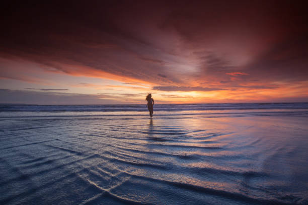istock Woman running on beach at sunset 870818408