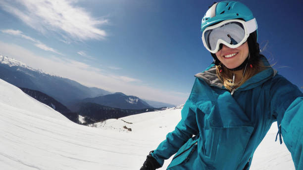 istock Female snowboarder taking selfie 870821330