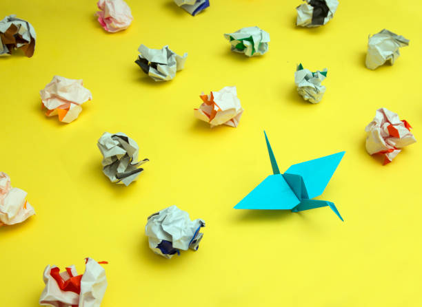 istock Origami Crane Surrounded by Crumpled Paper 870825188