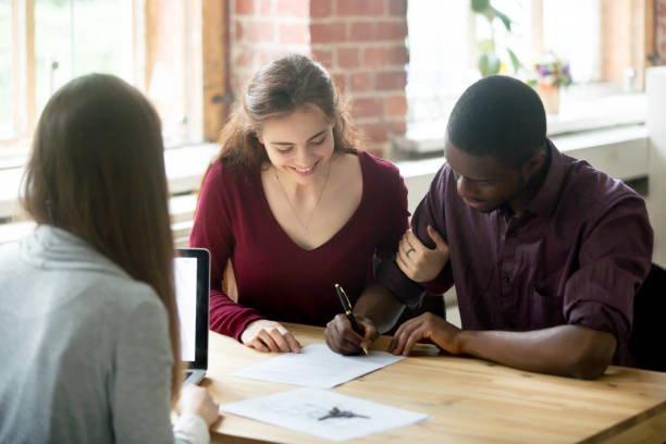 istock Multiethnic couple signing house purchase agreement. 870828536