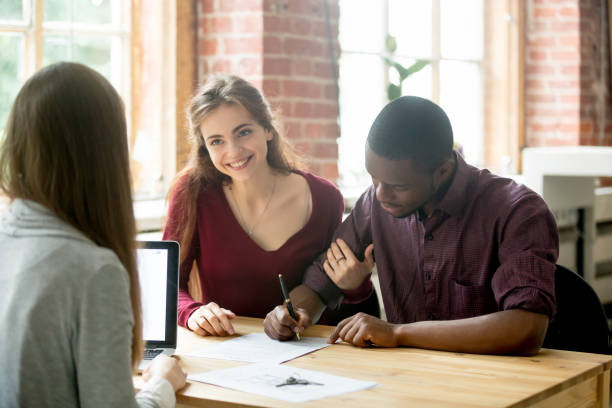 istock Multiethnic couple signing house purchase agreement. 870828582