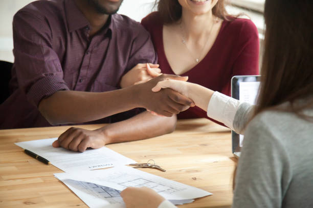 istock Young multiethnic couple shaking hands with real estate agent. 870828636