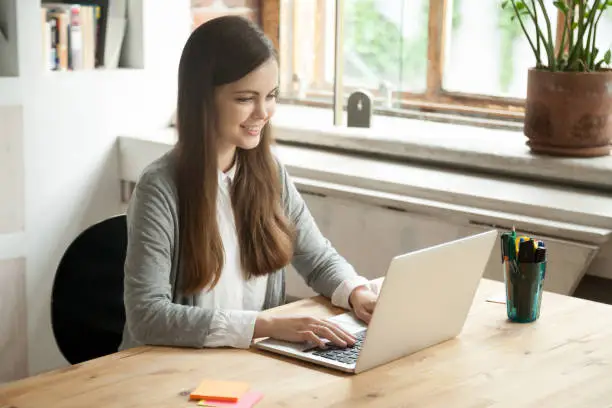 Photo of Happy smiling business woman working on laptop in office.