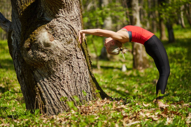 istock Young woman doing yoga in a forest 870831374