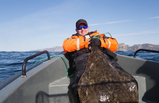 istock Fisherman holding the tail of a huge fish. horizontal frame 870835444