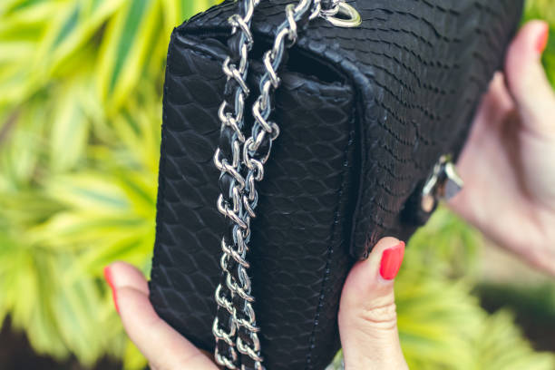 istock Closeup woman hands with fashion luxury snakeskin python handbag. Outdoors, Bali island 870836348
