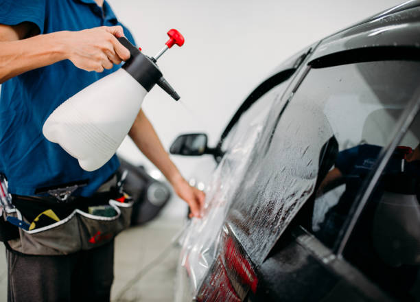 istock Male hand with spray, car window tint installation 870839056