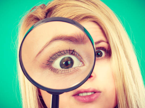 istock Woman looking through magnifying glass 870843420