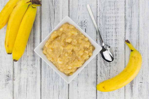 Mashed Bananas on a vintage background Mashed Bananas on a vintage background as detailed close-up shot (selective focus) mash food state stock pictures, royalty-free photos & images