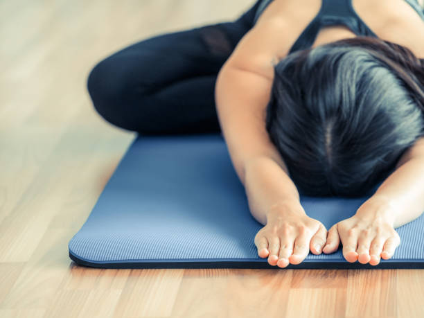 istock Woman practicing yoga pose in gym 870847748