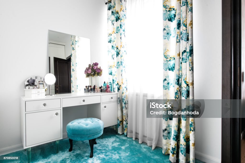 Cozy and modern feminine white dressing room with minimalist vanity table and mirror Dressing Table Stock Photo