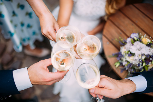 Four people make a celebratory toast on a wedding day