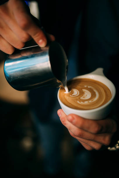 istock Barista drawing latte art on a coffee in white cup 870850960