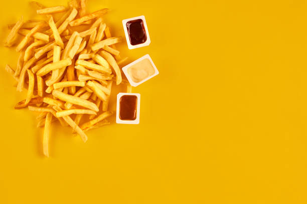 istock Fast food concept with greasy fried restaurant take out as onion rings, burger, fried chicken and french fries as a symbol of diet temptation resulting in unhealthy nutrition 870853672