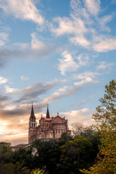 basilica di santa maria la real de covadonga, asturie, spagna, europa. splendido scenario di destinazione turistica in un tramonto autunnale con un vivace cielo colorato e una foresta verde in montagna. - covadonga foto e immagini stock