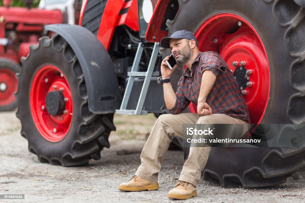 Doing business on the farm farmer and tractor Farmer Stock Photo