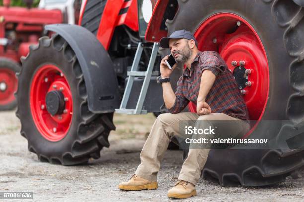 Doing Business On The Farm Farmer And Tractor Stock Photo - Download Image Now - Farmer, Tractor, Using Phone