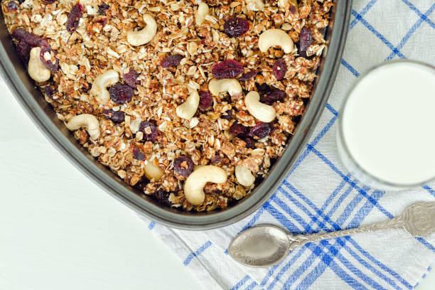 istock Granola on a baking sheet and yogurt on a light white background. Close-up 870864168