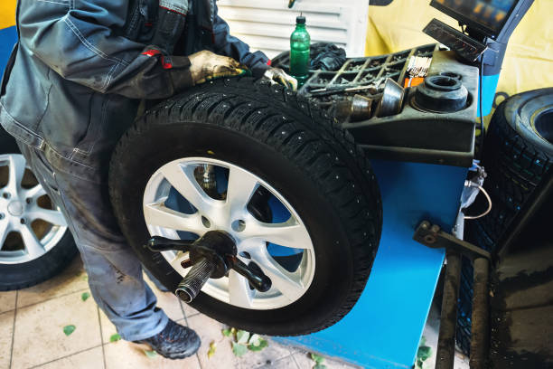 istock Mechanic worker makes computer tier wheel balancing on special equipment machine tool in repair service 870870338