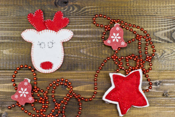 istock White deer and star of felt on wooden texture. 870874156