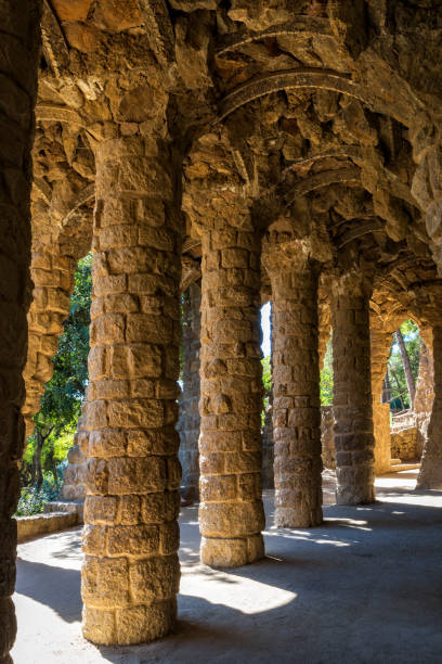 Columns supporting the undulating ceiling covered in mosaic tiles, showcasing Antoni Gaudí's modernist architecture in the iconic Park Güell, Barcelona, Spain
