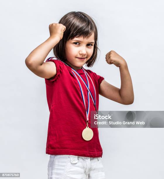 Little Cheeky Girl With Medals Smiling Showing Young Female Power Stock Photo - Download Image Now